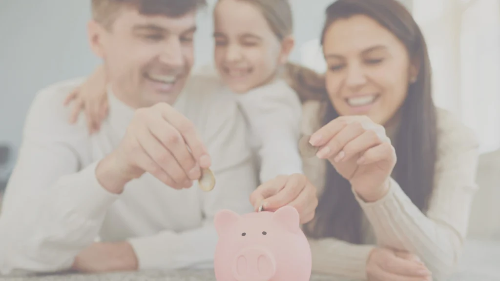 Smiling family saving coins into a pink piggy bank – illustrating smart savings and life insurance benefits.