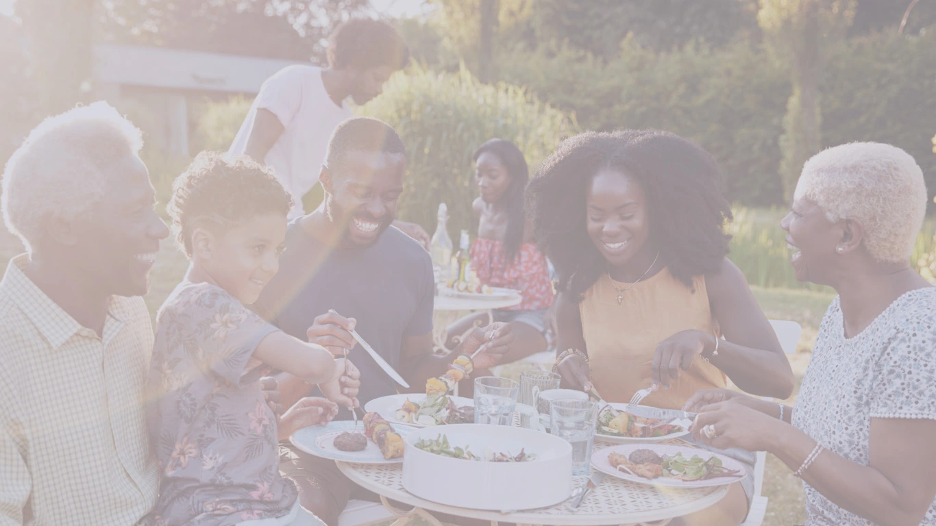 Multigenerational Black family enjoying an outdoor meal together – representing love and protection with life insurance.