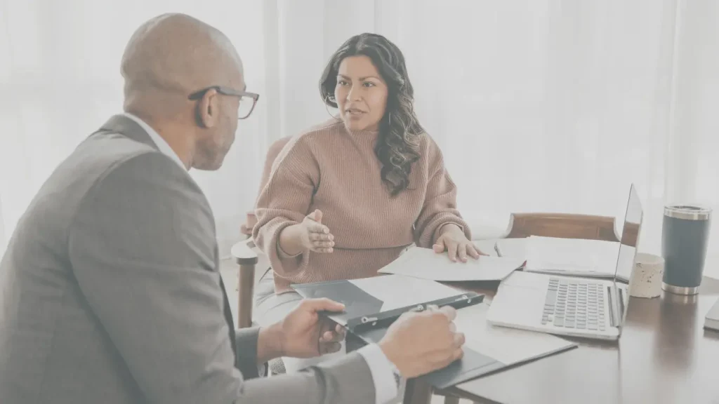 Woman discussing important financial documents with her life insurance advisor — critical planning moments.