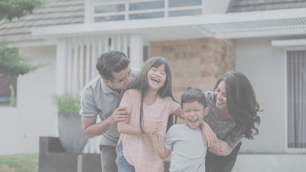 Canadian family smiling in front of their home after securing affordable life insurance