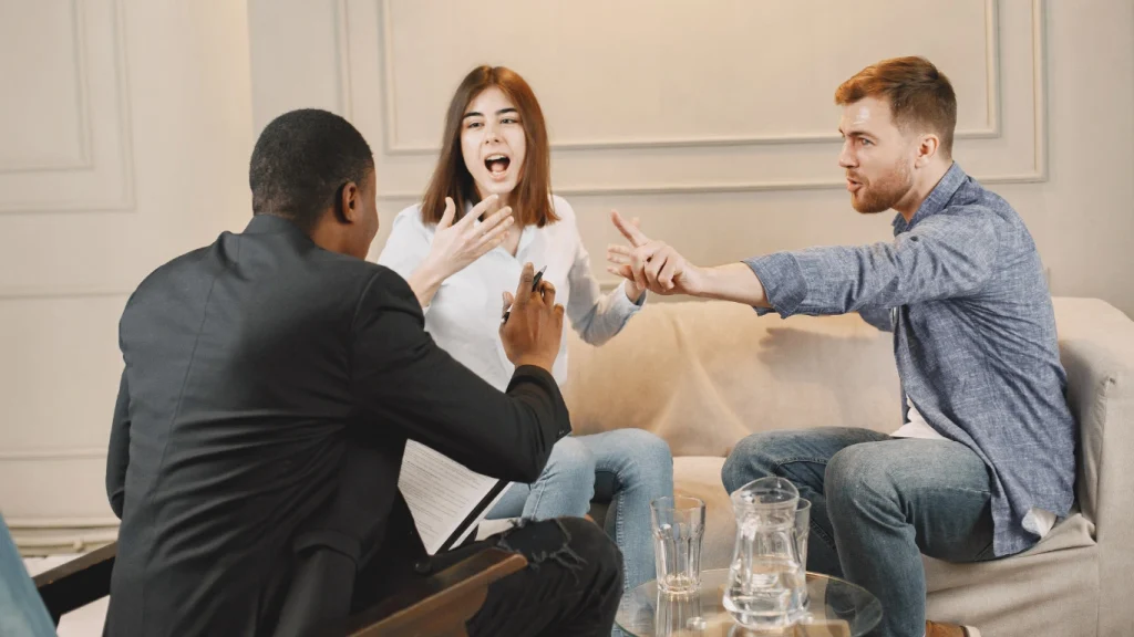 Couple in a heated discussion with a financial advisor — avoid future disputes with the right life insurance plan.