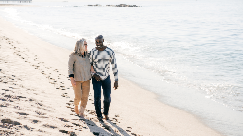Couple walking on the beach talking about the best life insurance for seniors in Canada