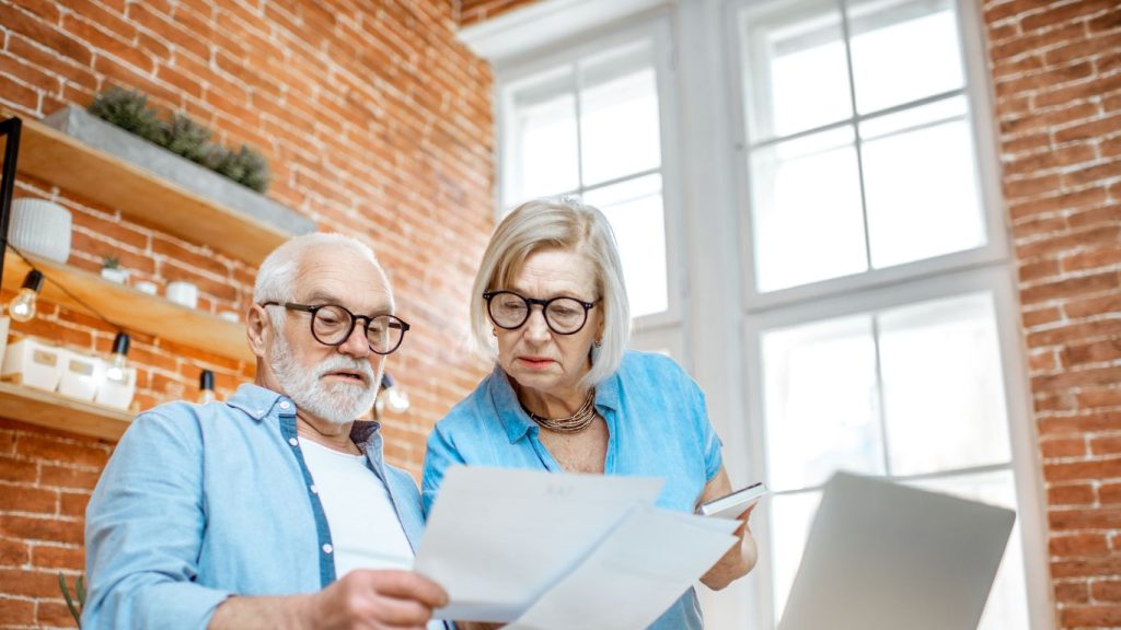 Canadian senior reviewing life insurance policy at home